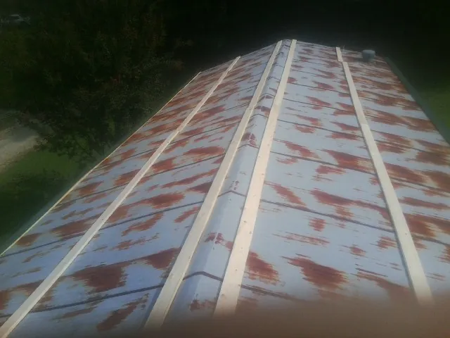 Rusted metal roof panels with new wood purlins before replacement — Storm Damage Roof Repair in High Springs by Roofing Brothers